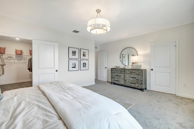 carpeted bedroom featuring a closet and a walk in closet