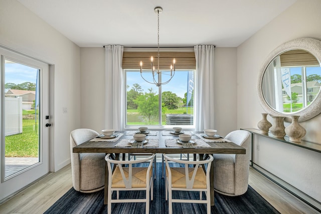 dining room with light hardwood / wood-style flooring and a chandelier