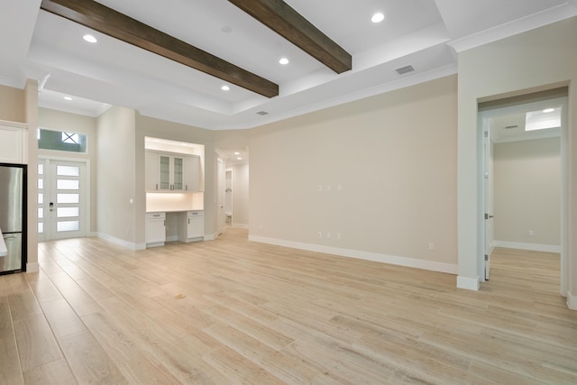 unfurnished living room featuring beamed ceiling, ornamental molding, built in desk, and light hardwood / wood-style floors