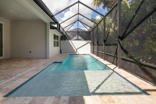 view of pool with a patio area and glass enclosure