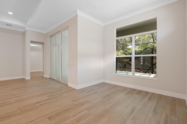 empty room with crown molding and light hardwood / wood-style flooring