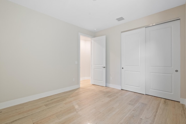 unfurnished bedroom featuring a closet and light wood-type flooring