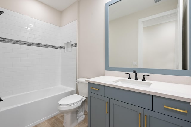 full bathroom with vanity, toilet, hardwood / wood-style flooring, and tiled shower / bath combo