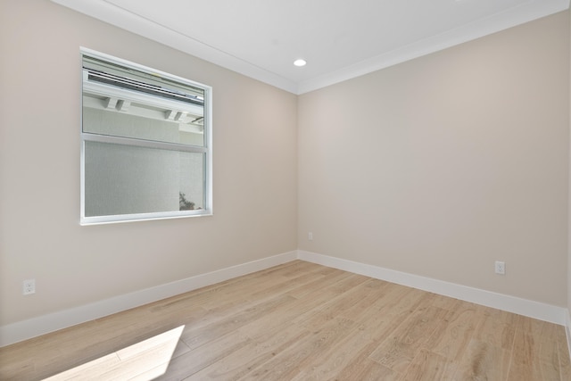 empty room with light hardwood / wood-style floors and crown molding