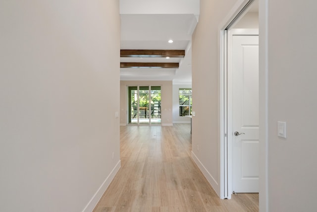 hall featuring beamed ceiling and light hardwood / wood-style flooring