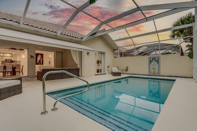 pool at dusk with a patio and glass enclosure