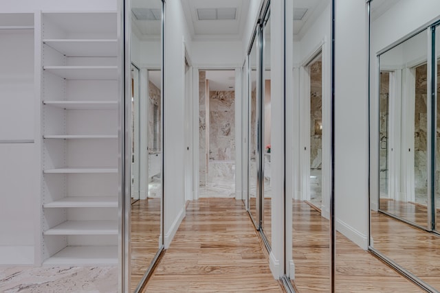 corridor featuring built in features and light hardwood / wood-style floors