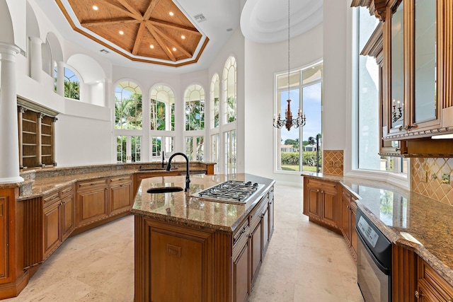 kitchen featuring brown cabinetry, stainless steel gas cooktop, coffered ceiling, a high ceiling, and recessed lighting