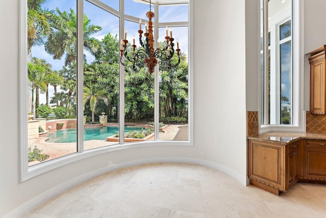 interior space with decorative backsplash, baseboards, and a chandelier