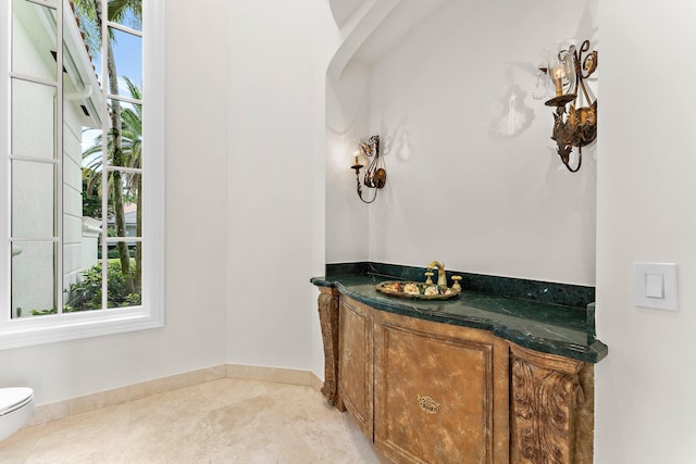 bathroom with toilet and baseboards