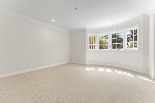 spare room featuring recessed lighting, light carpet, crown molding, and baseboards