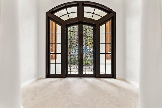 doorway to outside with french doors and baseboards