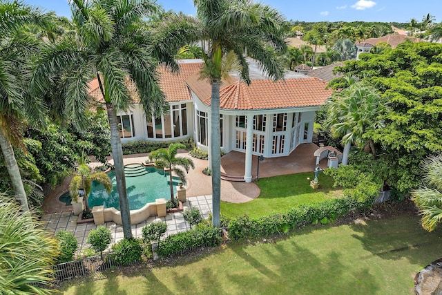 back of property with a tile roof, an outdoor pool, french doors, fence, and a patio