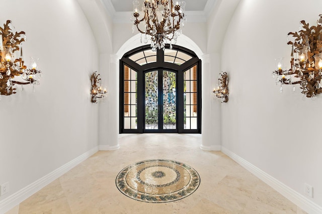 entrance foyer with arched walkways, ornamental molding, and an inviting chandelier