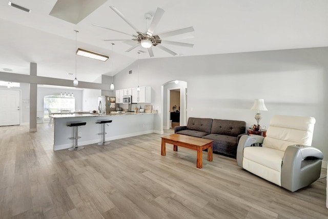 living room with high vaulted ceiling, light wood-type flooring, and ceiling fan