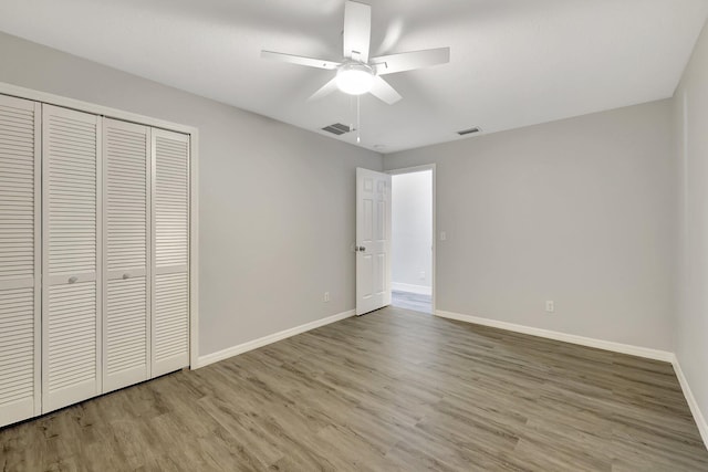 unfurnished bedroom featuring a closet, light hardwood / wood-style floors, and ceiling fan