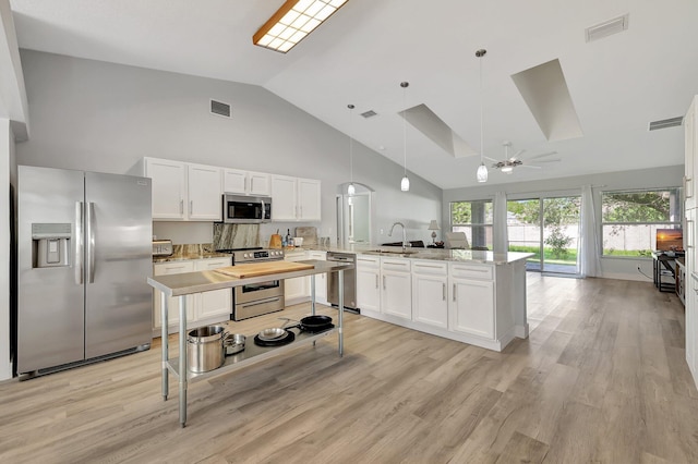 kitchen with sink, ceiling fan, stainless steel appliances, decorative light fixtures, and white cabinets