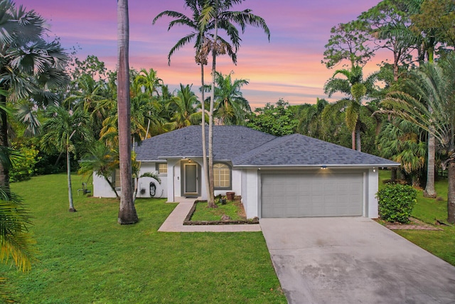 ranch-style home with a yard and a garage