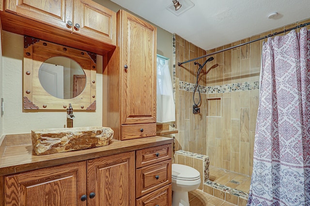 bathroom featuring tile patterned floors, vanity, toilet, and walk in shower