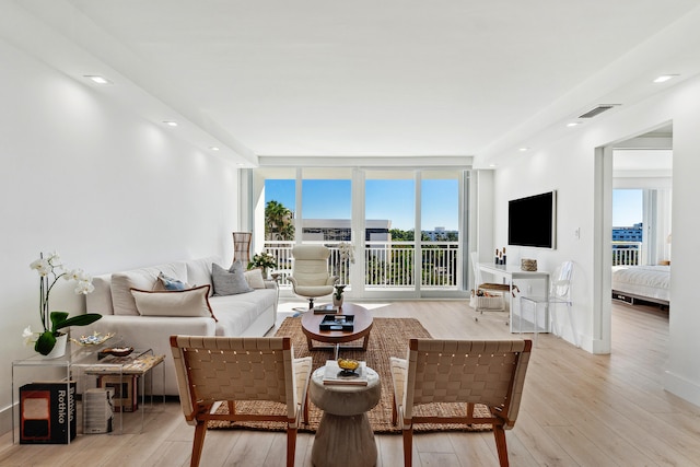 living room with expansive windows and light hardwood / wood-style floors