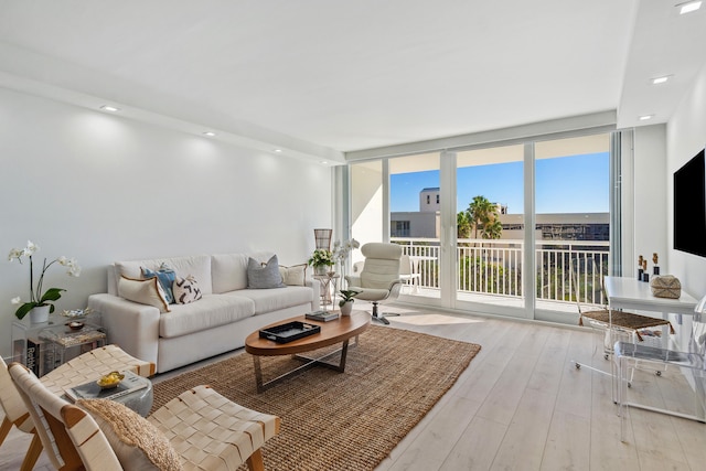 living room with light hardwood / wood-style floors and a wall of windows