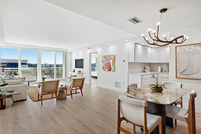 dining area with a notable chandelier and light wood-type flooring