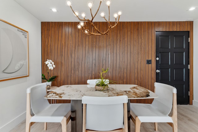 dining room with light hardwood / wood-style floors and an inviting chandelier