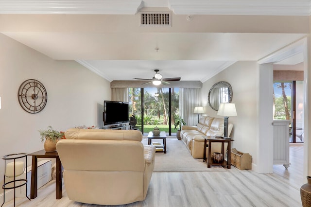 living room with ornamental molding, light hardwood / wood-style flooring, ceiling fan, and plenty of natural light