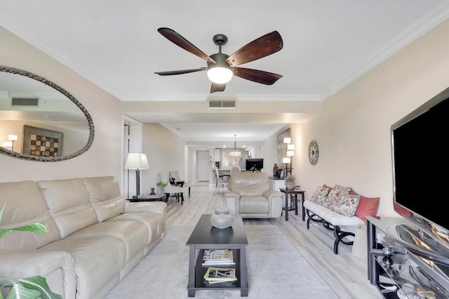 living room featuring light hardwood / wood-style floors, ornamental molding, and ceiling fan with notable chandelier