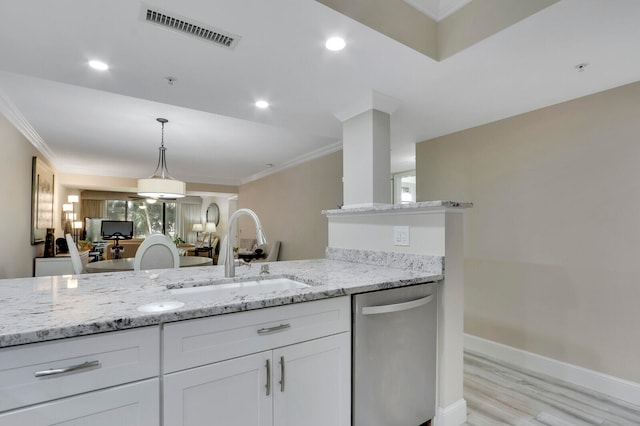 kitchen with stainless steel dishwasher, sink, white cabinetry, and light stone counters