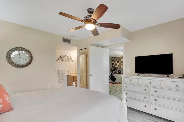 bedroom featuring connected bathroom, ceiling fan, and light hardwood / wood-style flooring