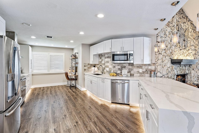 kitchen featuring stainless steel appliances, a sink, visible vents, and wood finished floors