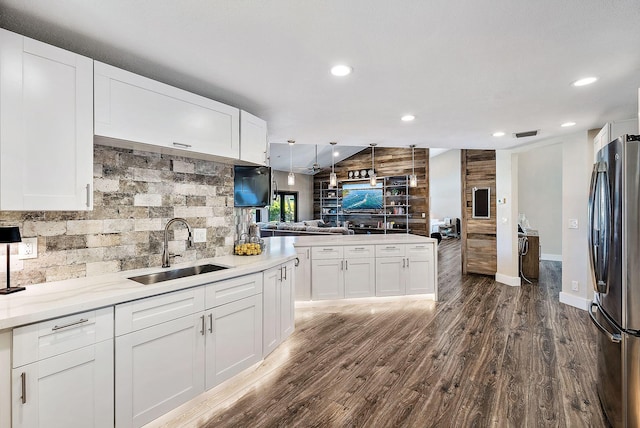 kitchen with white cabinets, dark hardwood / wood-style flooring, sink, and stainless steel fridge