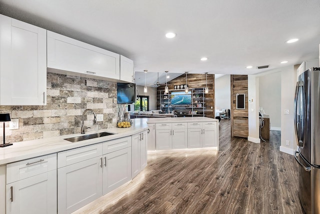 kitchen with freestanding refrigerator, open floor plan, a sink, and white cabinets