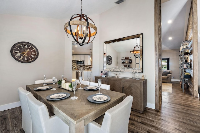 dining area with dark hardwood / wood-style flooring, a chandelier, and vaulted ceiling