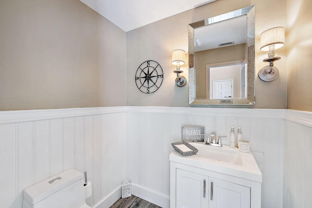 bathroom with toilet, hardwood / wood-style flooring, and vanity