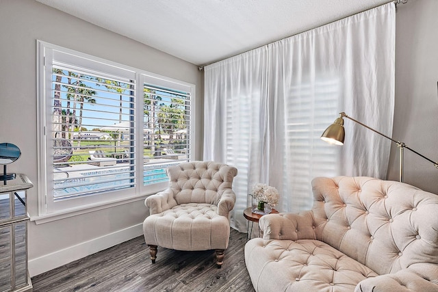 sitting room featuring baseboards and wood finished floors
