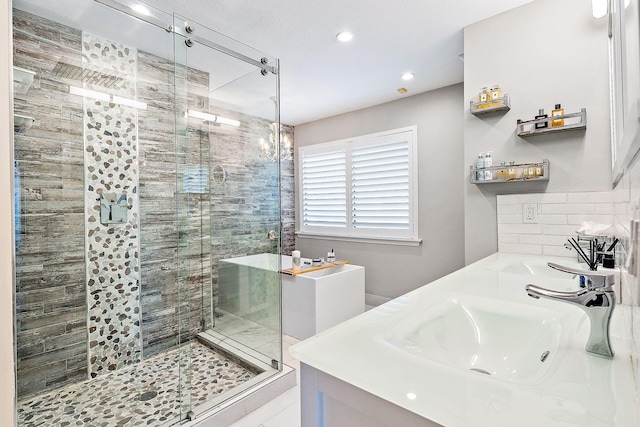 bathroom featuring backsplash, recessed lighting, a sink, and a stall shower