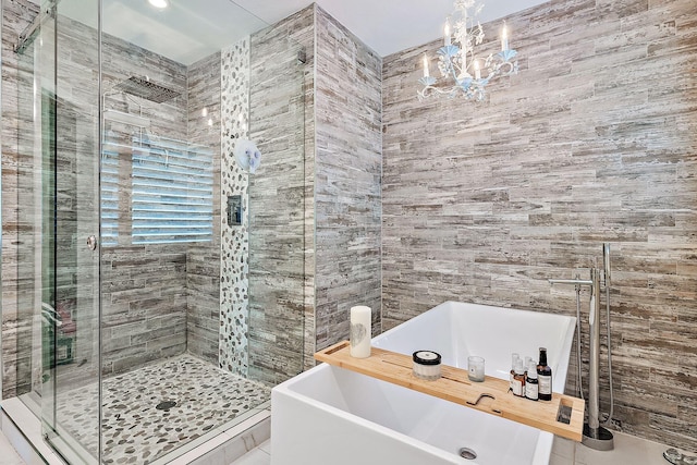 bathroom featuring tile patterned flooring, a notable chandelier, tile walls, and separate shower and tub