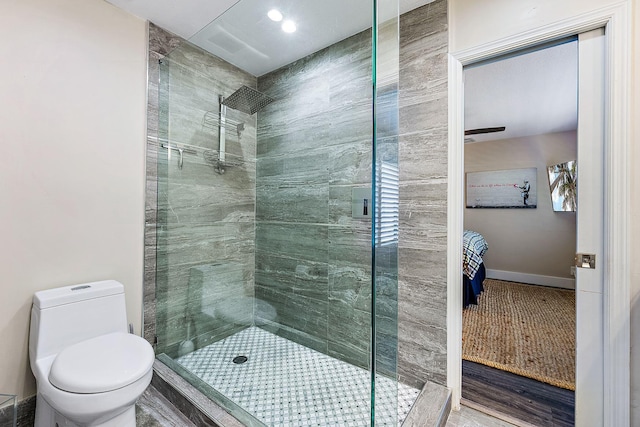 bathroom featuring baseboards, a shower stall, and toilet