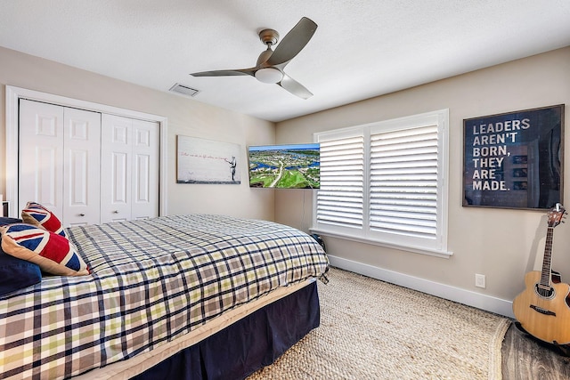 carpeted bedroom featuring a closet, a textured ceiling, and ceiling fan