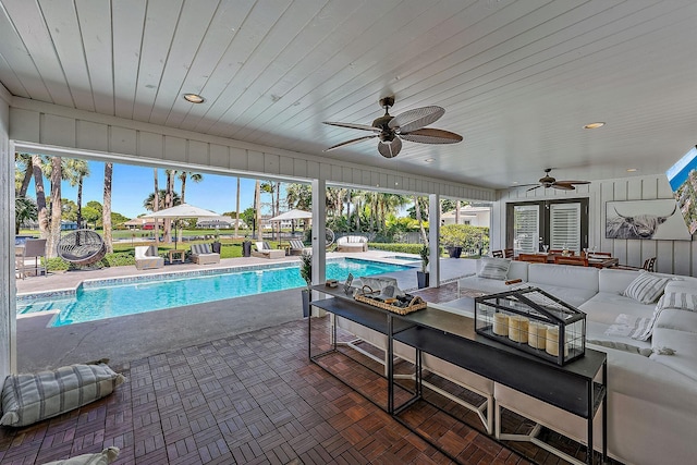 view of pool featuring an outdoor living space, a patio area, and ceiling fan