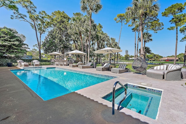 pool with a patio and an in ground hot tub