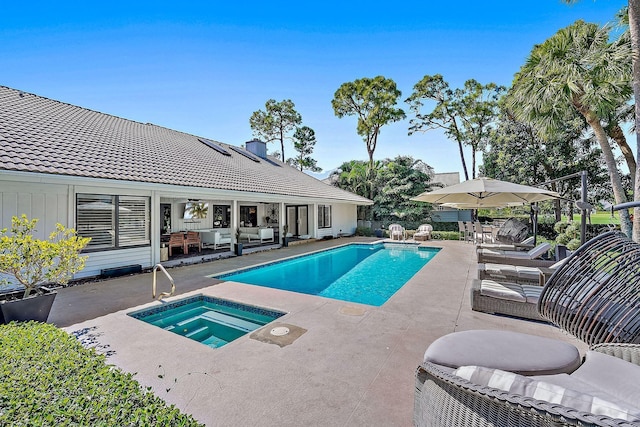 pool with a patio, an in ground hot tub, and an outdoor hangout area
