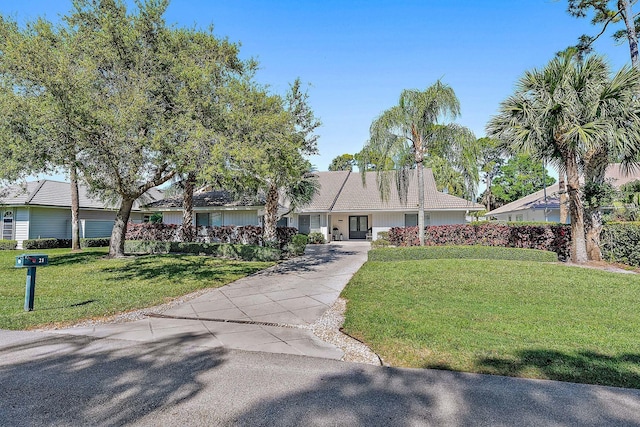 view of front of property with aphalt driveway and a front lawn