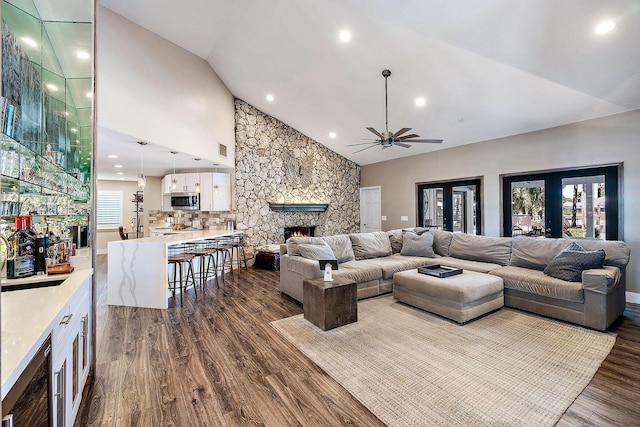 living room featuring a fireplace, ceiling fan, high vaulted ceiling, dark wood-type flooring, and recessed lighting