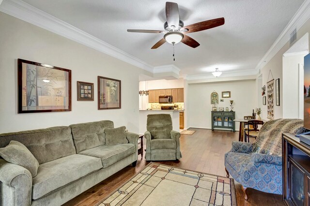 living room featuring light wood-style flooring, a ceiling fan, and crown molding