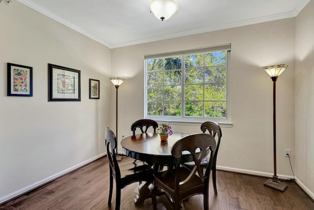 dining space featuring baseboards, ornamental molding, and wood finished floors