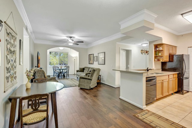 kitchen featuring arched walkways, open floor plan, dishwasher, open shelves, and light wood finished floors