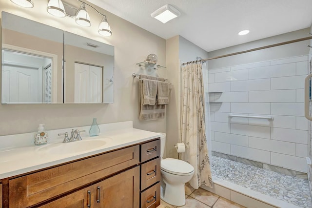 full bathroom featuring visible vents, toilet, vanity, tile patterned flooring, and tiled shower